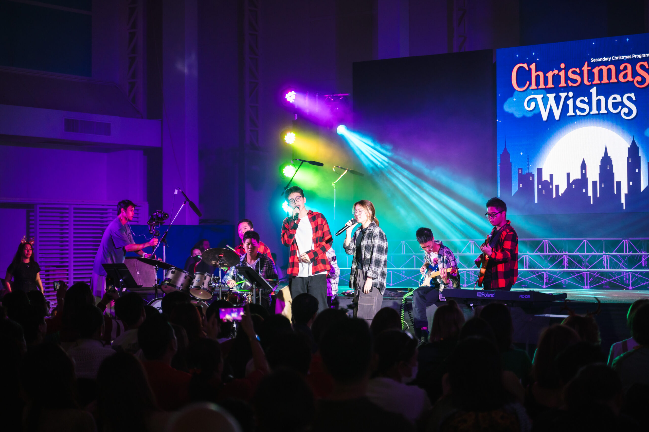 A band performing on stage with male and female lead singers