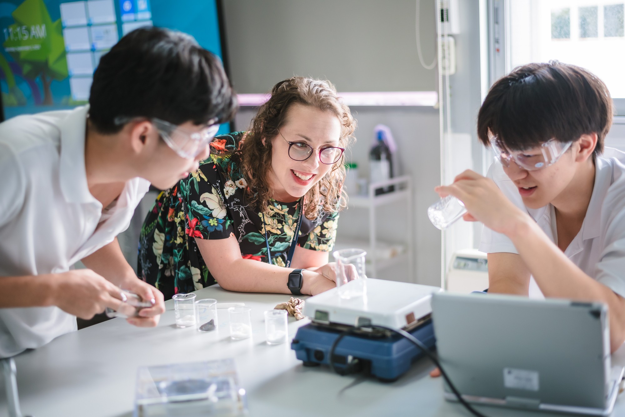 Students experimenting with laboratory tools in a class with their teacher Caption: Putting theories to test at AP Chemistry class