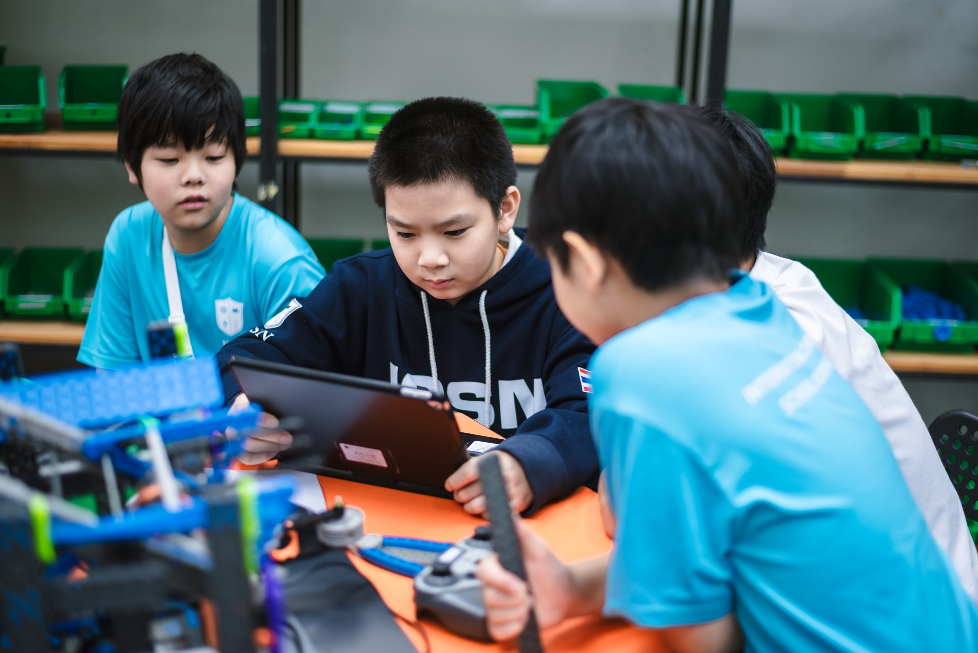 Students sharing a device in robotics class
