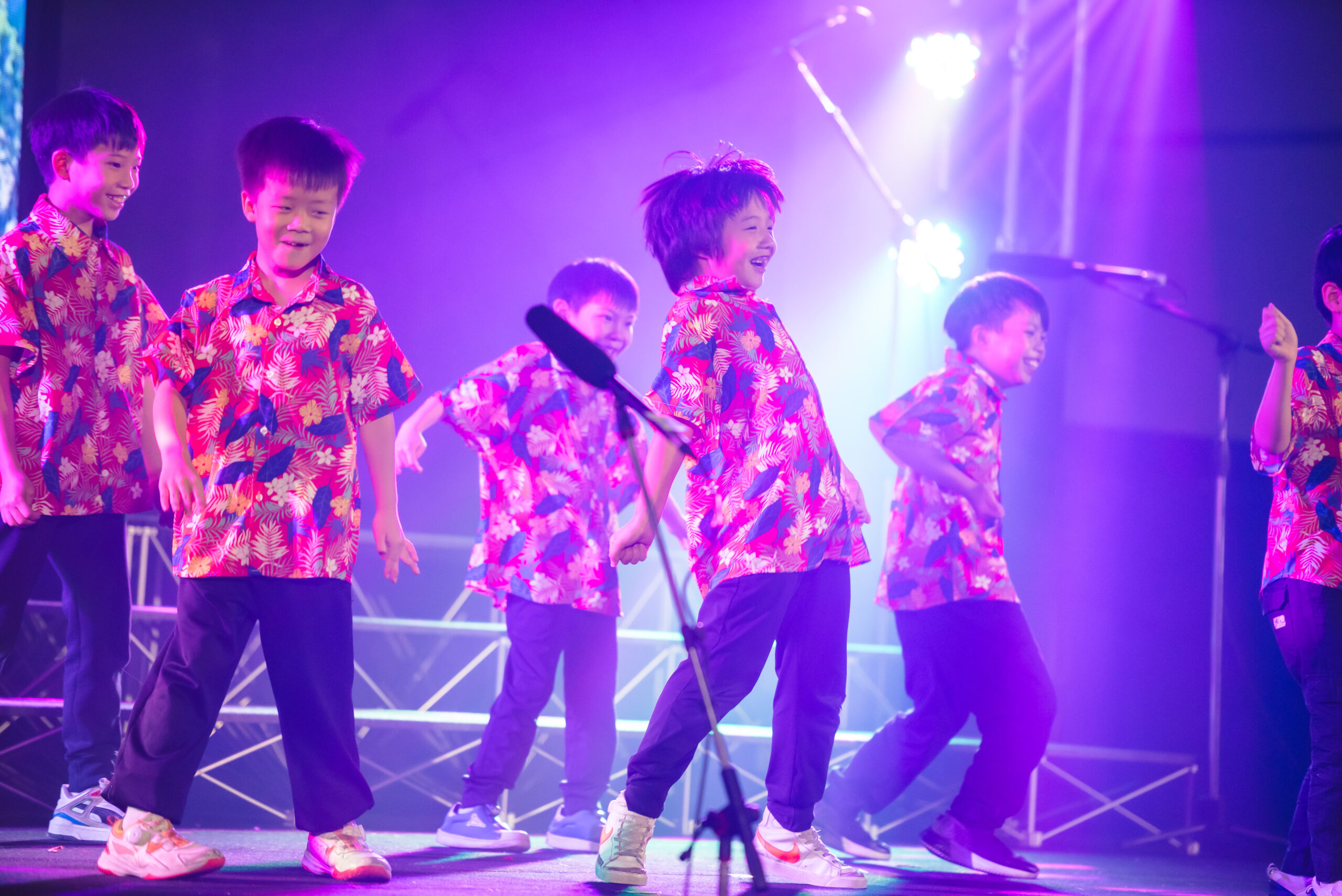 students in colorful floral shirts having fun at their dance presentation