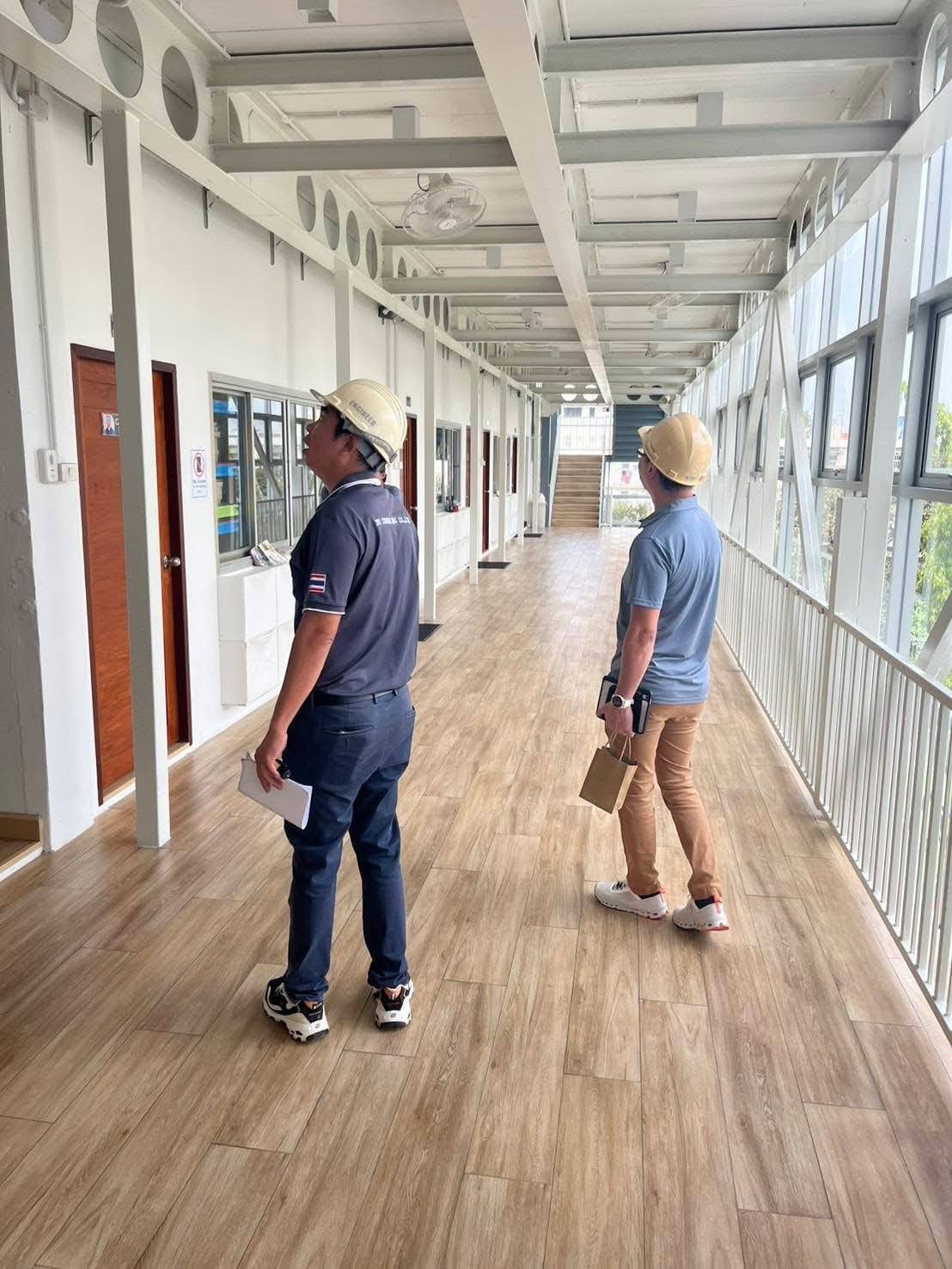 Two structural engineers wearing hard hats inspecting a building